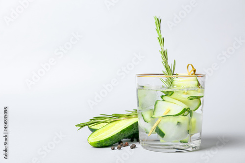 Photography Glass of cold gin tonic and cucumber slices on light background