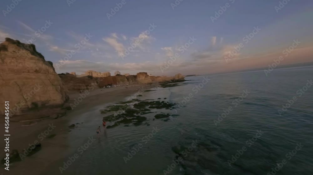 FPV Drone Aerial sunset flight view at Praia dos Careanos, in Portimao, western Algarve tourism destination region, Portugal. FPV Drone Aerial sunset flight view at Praia dos Careanos, in Portimao, western Algarve tourism destination region, Portugal.
