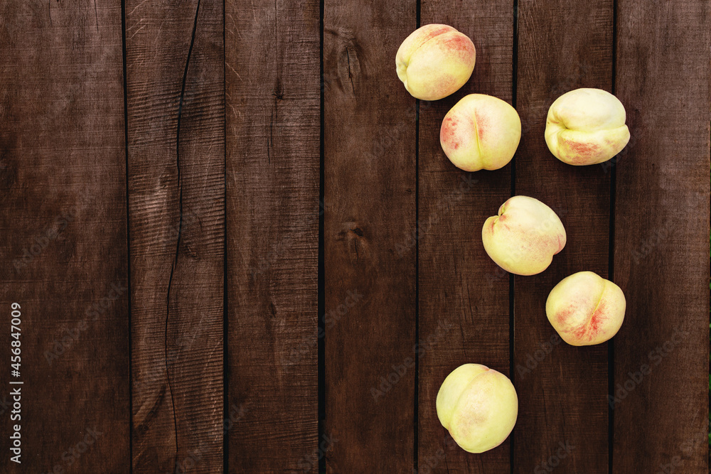 Large and big juicy peaches on brown wooden table background with boards Large and big juicy peaches on brown wooden table background with boards