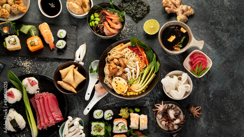 Japanese dishes and snacks on gray background.