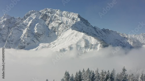Aerial drone view over frosty trees and fog, towards a alpine peak, in Bavaria photo