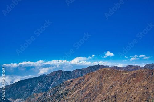 The natural scenery of the tawny mountains under the blue sky and white clouds. View of the mountains along the way. Travel to the Tsomgo Lake (Changu Lake), in the Indian state of Sikkim.