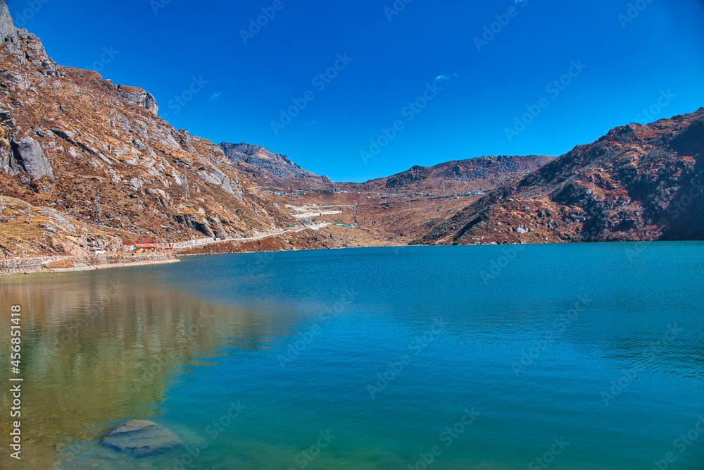 An alpine lake surrounded by mountains. The water of the lake is blue. View of the mountains along the way. Travel to the Tsomgo Lake (Changu Lake), in the Indian state of Sikkim.