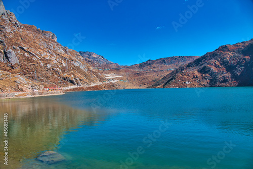 An alpine lake surrounded by mountains. The water of the lake is blue. View of the mountains along the way. Travel to the Tsomgo Lake  Changu Lake   in the Indian state of Sikkim.