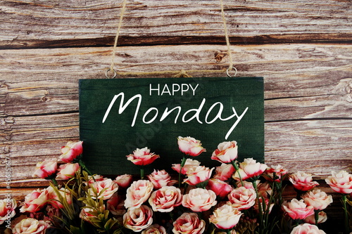 Happy Monday typography text with pink flowers bouquet on wooden background © may1985