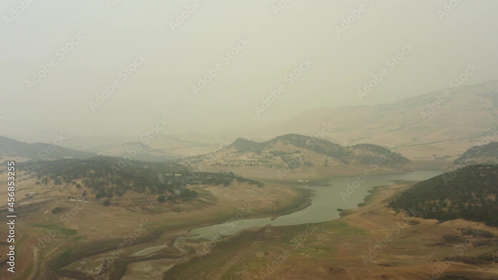 Descending drone aerial of a lake bed drying up during drought conditions. Emigrant Lake in Southern Oregon with smoke in the air Descending drone aerial of a lake bed drying up during drought conditions. Emigrant Lake in Southern Oregon with smoke in the air