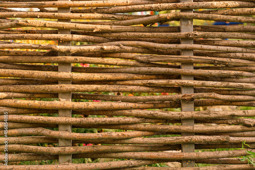 A fence made of woven tree branches. Wicker fence close-up