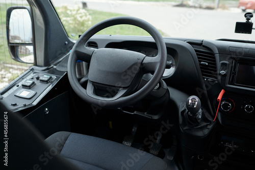 Close-up of drivers seat, bus dashboard and steering wheel, view through windshield