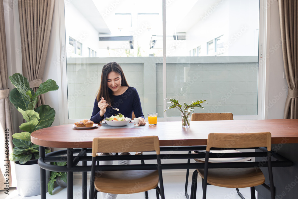 Having meal concept a pretty woman mixing zero calories salad dressing with a green salad in the bowl Having meal concept a pretty woman mixing zero calories salad dressing with a green salad in the bowl