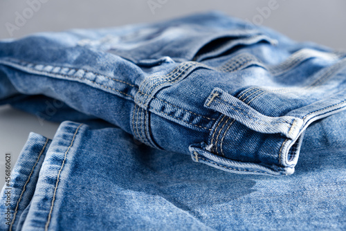 a blue light jeans on a grey background. Close up. Sunlight (ID: 456860621)