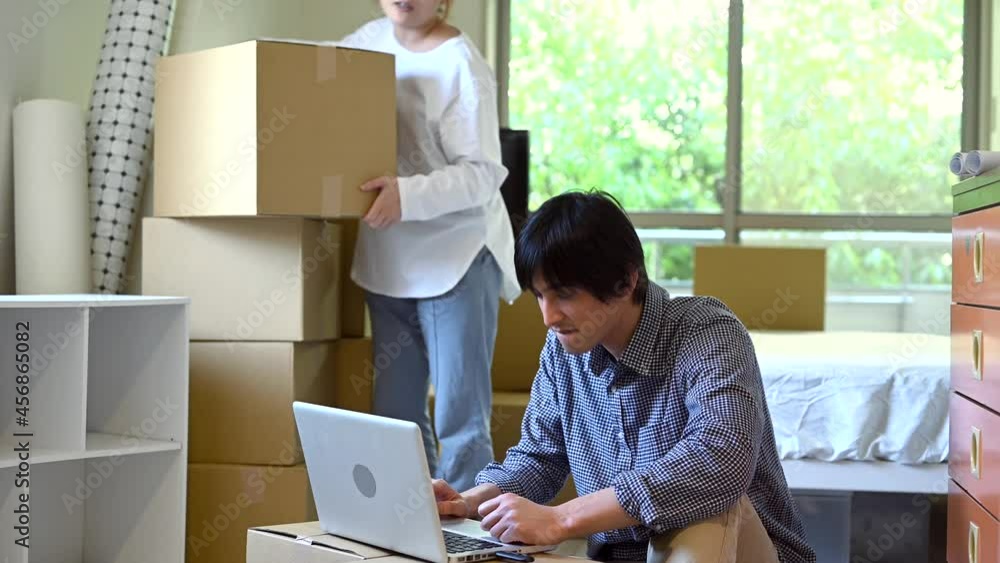 引っ越し/ダンボール箱の上でラップトップの操作をする男性 引っ越し/ダンボール箱の上でラップトップの操作をする男性