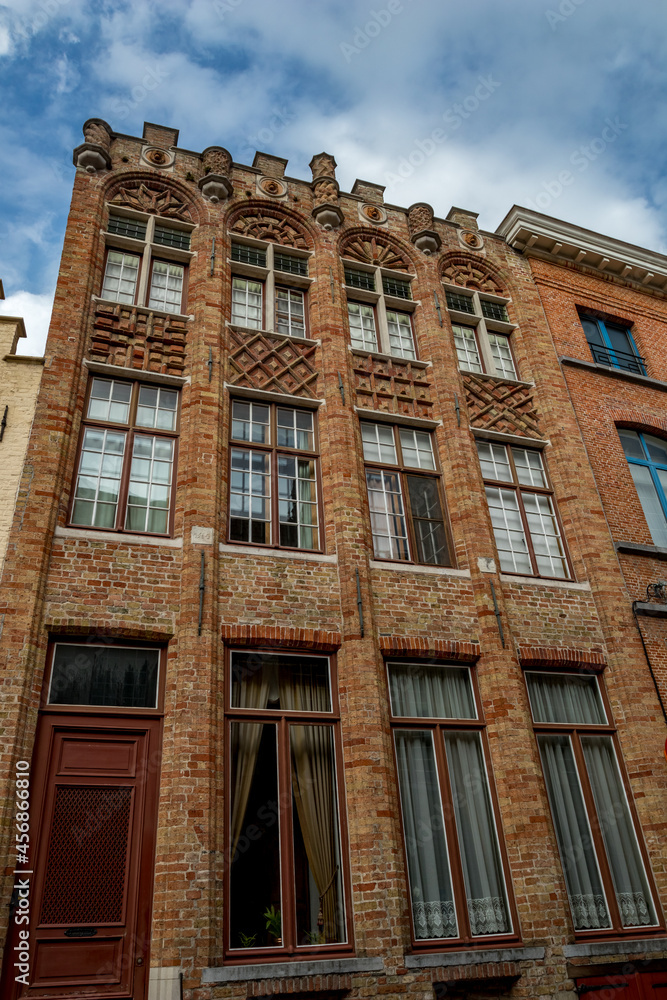 So many windows on that brick house! Street view of old Bruges, Belgium, cloudy summer day So many windows on that brick house! Street view of old Bruges, Belgium, cloudy summer day