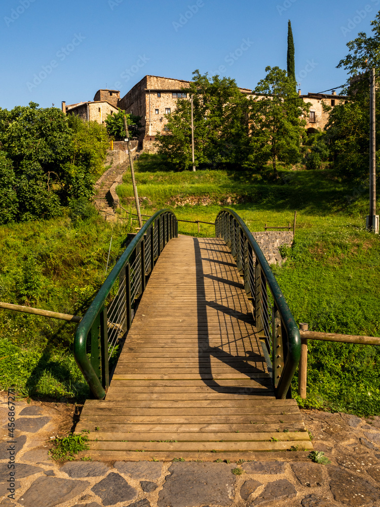 wooden and metal bridge leading to a village