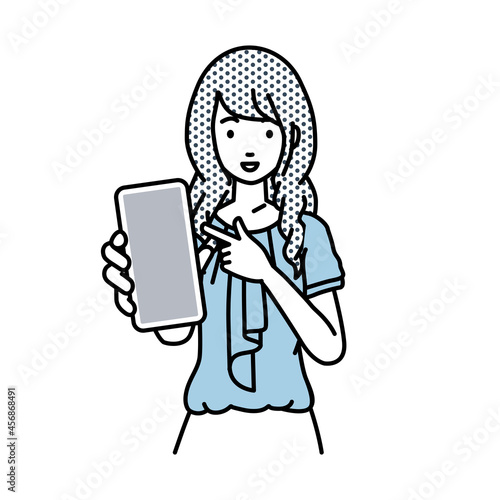 立ってスマートフォンを指差してこちらに向けて見せているオフィスカジュアルの女性