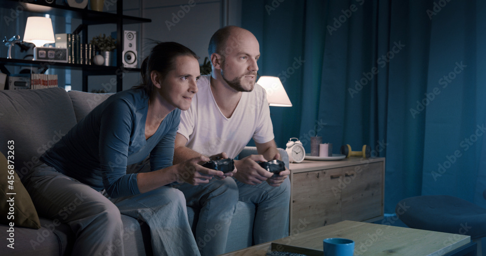Friends playing video games together at home
