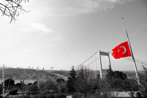 Half-staff Turkish Flag on the pole and monochrome cityscape of Istanbul photo