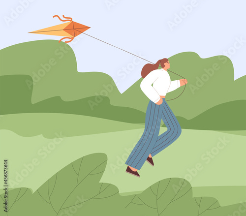 Person running forward with flying air kite, playing with joy and ease outdoo...