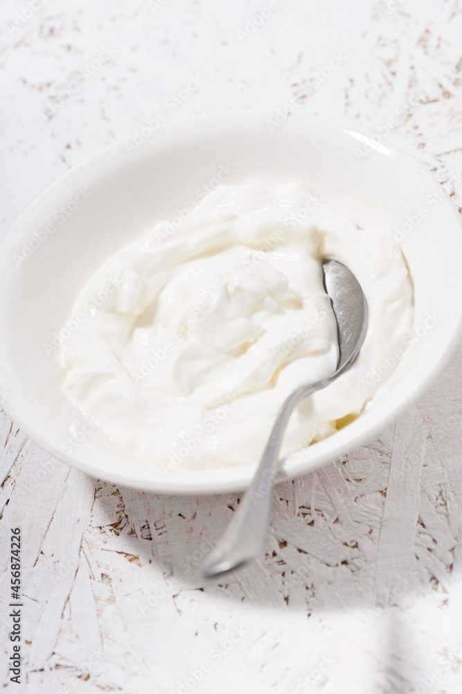 thick Greek yogurt in a bowl, vertical thick Greek yogurt in a bowl, vertical