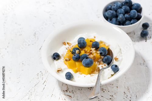 thick Greek yogurt with mango and blueberries
