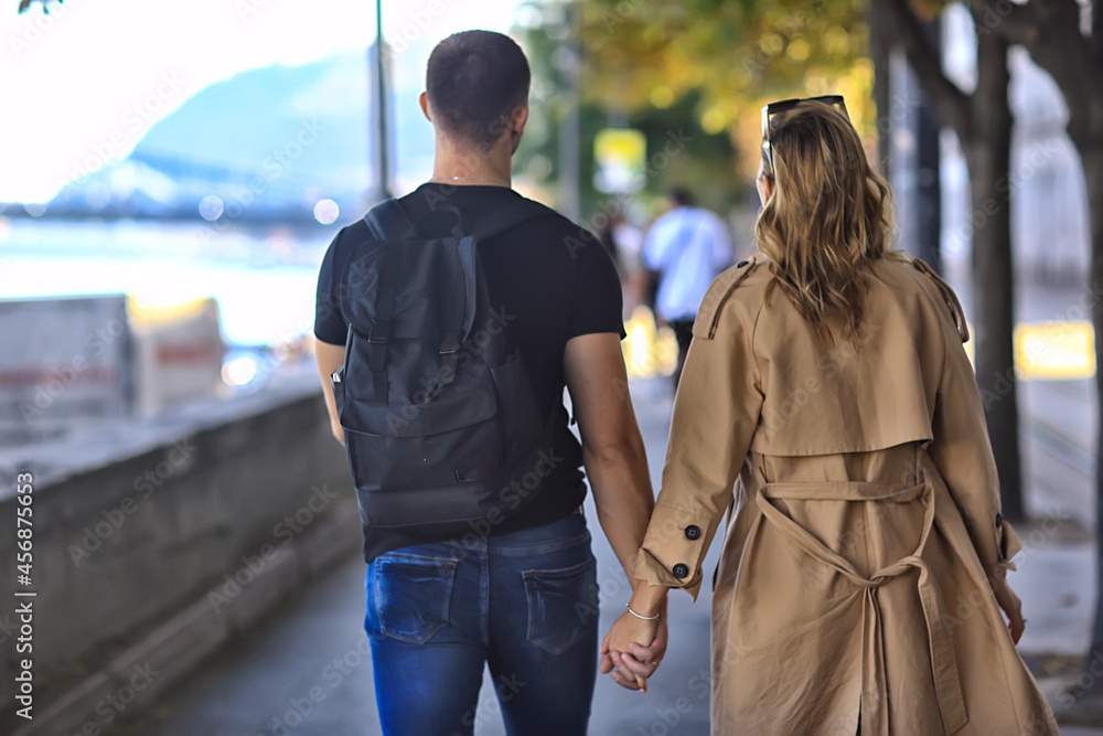 spring walk guy and girl back view, couple walks in the city seasonal view spring walk guy and girl back view, couple walks in the city seasonal view