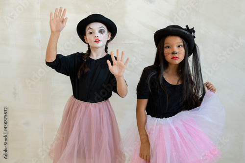 Two cute girls with halloween makeup performing pantomime in front of camera photo