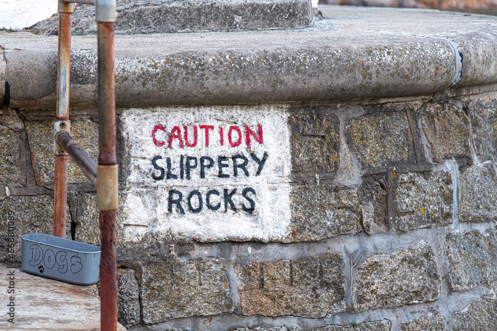 Caution Slippery Rocks sign on the Cornish coast