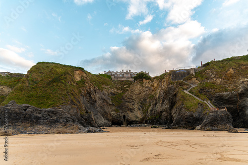 The rugged coastline of Newquay, Cornwall, with the Hotel Victoria perched on top of the cliff and the tunnel entrance to its life seen below