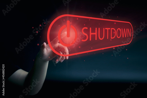human hand presses the shutdown button on the virtual screen. concept of a system shutdown or stops working. with space to copy or design business photo