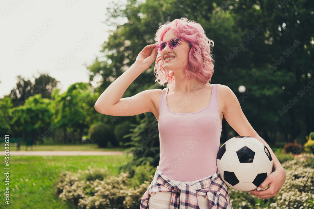 Obraz premium Portrait of attractive cheerful girl spending vacation free time holding ball touching specs on fresh air outdoors