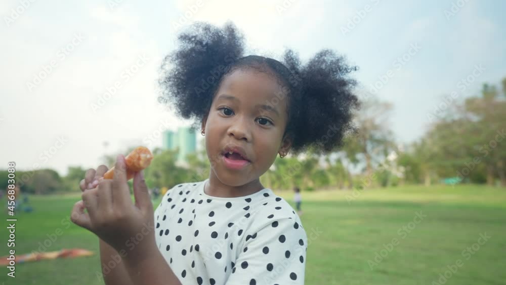 Holiday concept of 4k Resolution. Young girl happily eating sausages in the garden. Holiday concept of 4k Resolution. Young girl happily eating sausages in the garden.