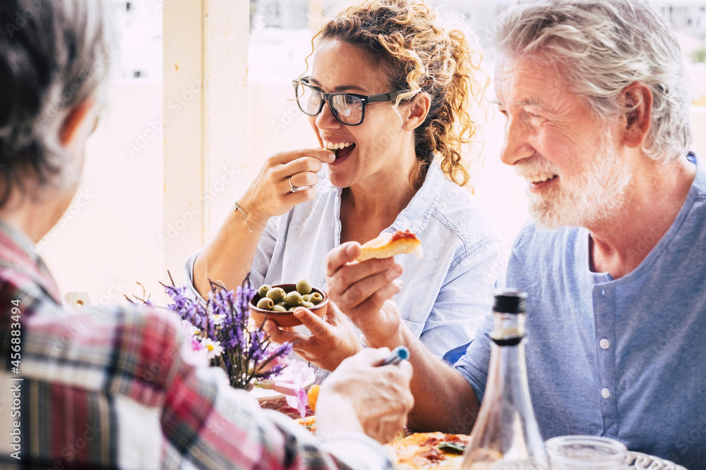 People having fun and having lunch on dining table. Spending quality time with family and friends. Loving happy multi generation family enjoying together food and drinks People having fun and having lunch on dining table. Spending quality time with family and friends. Loving happy multi generation family enjoying together food and drinks