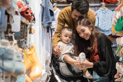 father and mother shopping at the baby shop with their son in the stroller