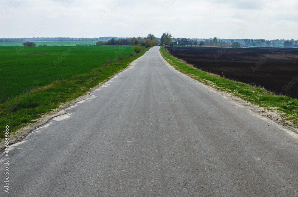 Empty asphalt road leading to the village Empty asphalt road leading to the village