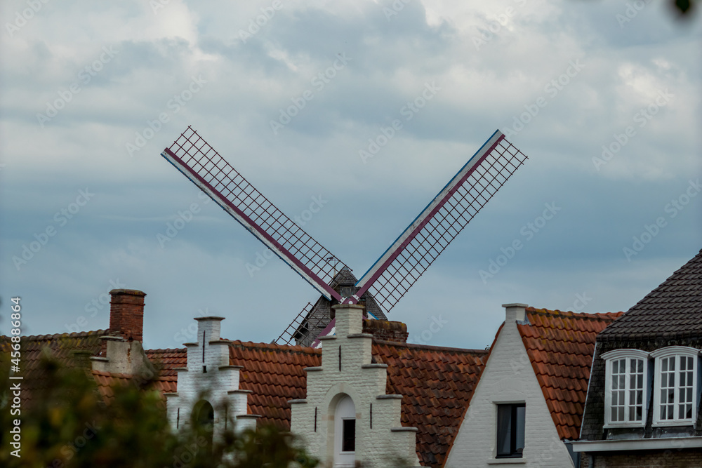 Partial view of a windmill hidden behind houses, street view, Bruges, Belgium