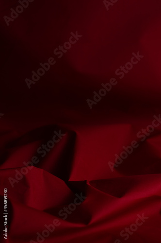 Fototapeta Naklejka Na Ścianę i Meble -  Blurred background of crumpled, burgundy-red fabric.