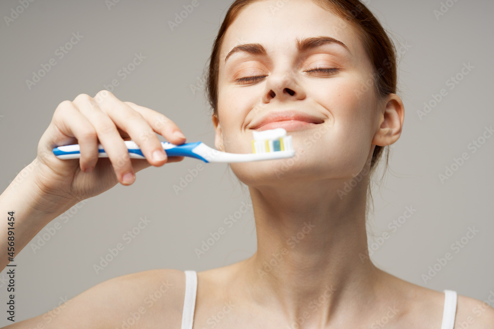 woman in white t-shirt cleans teeth hygiene lifestyle woman in white t-shirt cleans teeth hygiene lifestyle