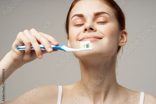 woman in white t-shirt cleans teeth hygiene lifestyle