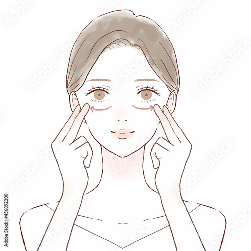 目の下をマッサージする女性