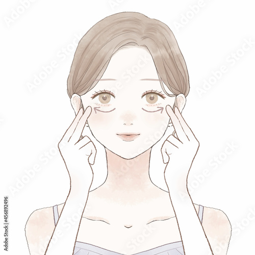 目の下をマッサージする女性