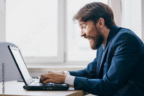 manager sitting at a desk in front of a laptop finance network technologies