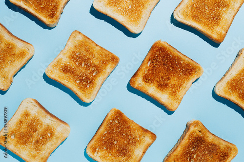 Close up pattern of French toast loaves on a bright blue contrast background. Morning breakfast brunch concept. Modern minimal food photography collage in pop-art style. Flat lay.