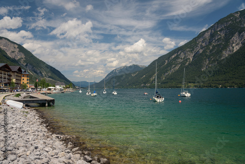 Sailing boats on shore of beautiful Achensee lake on cloudy summer day, Pertisau, Tyrol, Austria