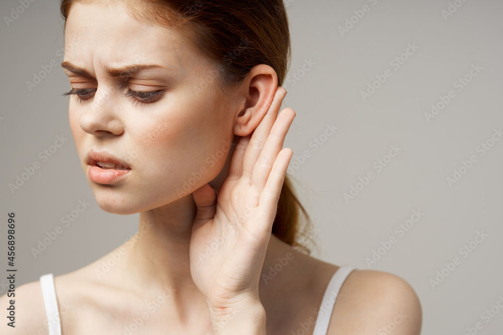 sick woman poor hearing disorders in white t-shirts light background sick woman poor hearing disorders in white t-shirts light background