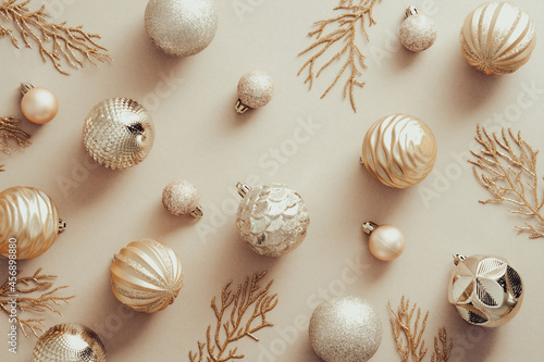 Christmas flat lay composition with golden balls and Xmas tree branches on beige background. Flat lay, top view.
