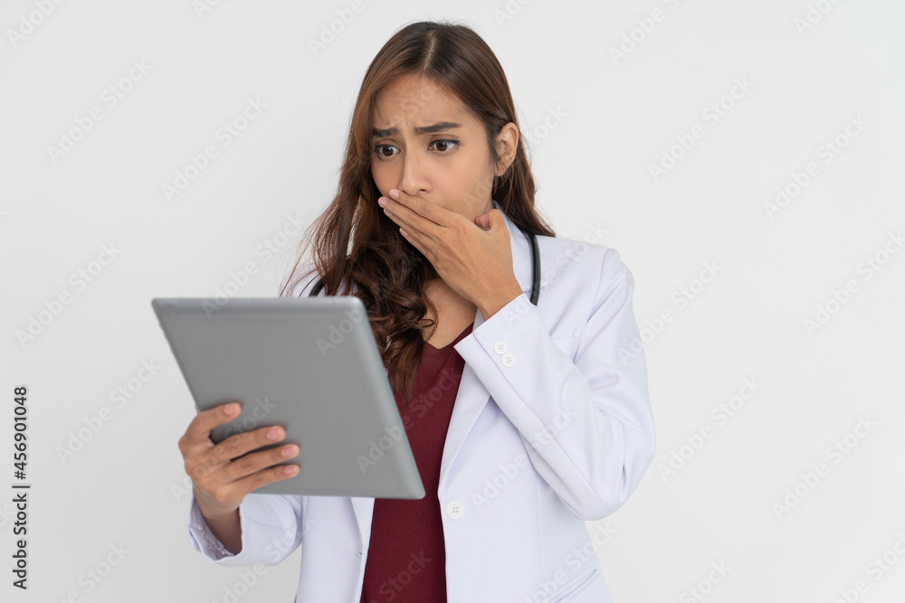 female doctor using tablet is shocked when she looks at tablet screen female doctor using tablet is shocked when she looks at tablet screen