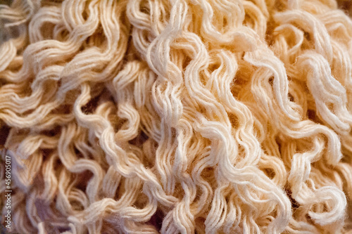 Close-up shot of a skein of beige woolen thread.