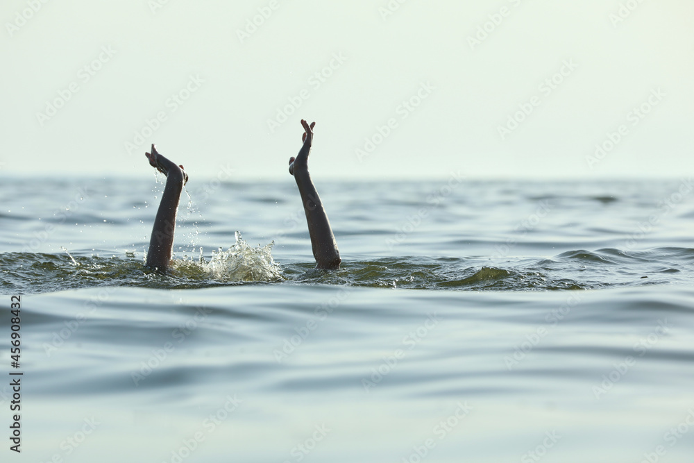 Drowning woman reaching for help in sea Drowning woman reaching for help in sea