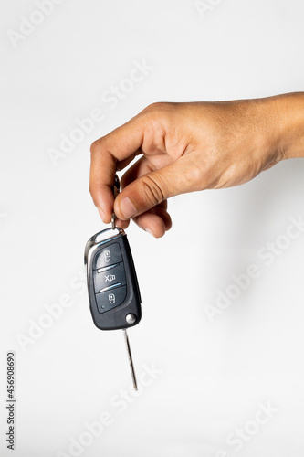 hand holding car remote isolated on white background 