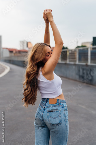 Young caucasian woman dancing outdoor gesturing with hands feeling free