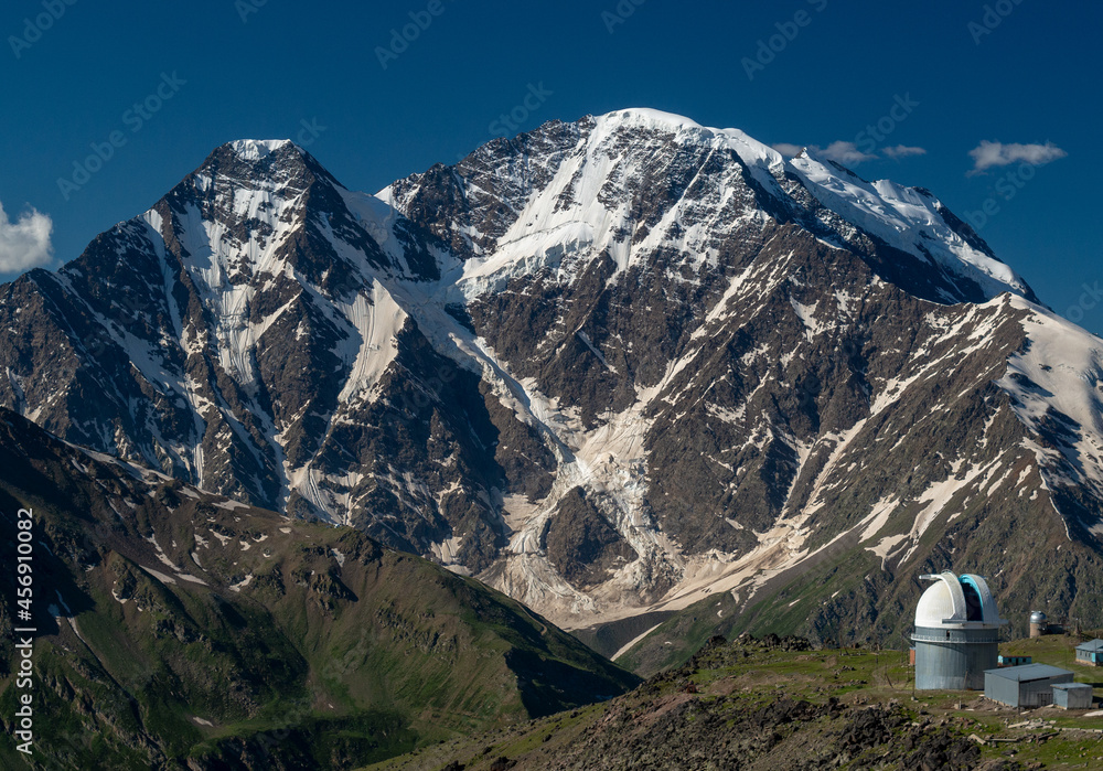 Observatory in the Caucasus mountains. Astronomical observatory on the background of snowy mountains. Beautiful mountain landscape.